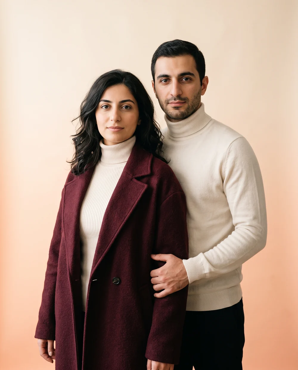 An Armenian couple standing together against a warm studio backdrop